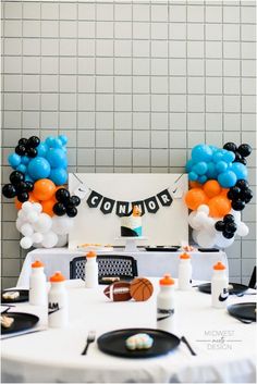 balloons and streamers decorate the table at a sports themed birthday party