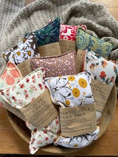 a wooden bowl filled with lots of different types of pillows on top of a table