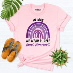 a pink shirt that says in may we wear purple