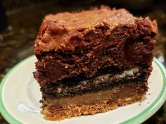 a piece of chocolate cake sitting on top of a white and green plate with a bite taken out of it