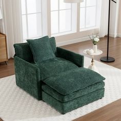 a living room with a green chair and ottoman on the floor next to a lamp