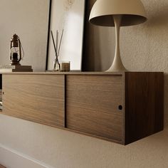 a wooden shelf with a lamp and pictures on it