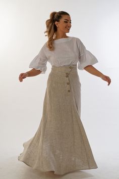 Opulent and graceful, the high-waisted linen maxi skirt catches the eye with irresistible modernity. Its asymmetric fastening, decorated with coconut buttons, adds a touch of freshness and exoticism. But what makes it truly unique are the hidden pockets, skillfully integrated into the seams, which combine practicality and style.  The skirt presents the natural color of linen, emphasizing its natural beauty. Its clean design perfectly hides any imperfections on the body, restoring harmony and correct proportions. With the grace of 6 precisely cut pieces that cut to the hem, the skirt wraps the body with tenderness and dynamism, inspiring femininity and style. This long linen skirt embodies the elegance and freshness of modern fashion, combining perfect comfort and sophistication. It is not Fitted Beige Linen Maxi Skirt, Fitted Linen Long Skirt, Chic Beige Linen Maxi Skirt, Elegant Linen Flared Maxi Skirt, Linen Maxi Skirt With Lining, Elegant White Linen Maxi Skirt, Elegant Fitted Linen Maxi Skirt, Elegant Long Linen Wrap Skirt, Beige Linen Wide Leg Maxi Skirt