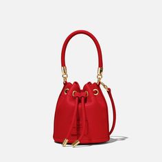 Discover the Marc Jacobs The Micro bucket bag, expertly crafted from red leather. This stylish accessory features a convenient top handle and an adjustable strap for versatile carrying options. The bag is adorned with an appliquéd logo patch and gold-tone hardware for a touch of luxury. Inside, you'll find a fully lined interior, while the drawstring closure ensures your belongings are kept secure. The designer colour is True Red, making this bag a bold and eye-catching addition to any outfit..D Versatile Faux Leather Bucket Bag For On-the-go, Formal Red Bucket Bag With Gold-tone Hardware, Red Shoulder Bucket Bag With Gold-tone Hardware, Marc Jacob’s Bucket Bag, Red Crossbody Bucket Bag With Gold-tone Hardware, Tiffany Jewelry, Marc Jacobs Bag, Leather Bucket, True Red