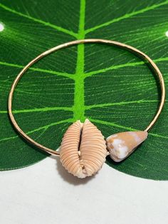 This listing is for a beautiful bangle with the most perfect and stunning Granulated Cowry Shell which is endemic to Hawaii. Paired with a small ocean worn Rat Cone Shell you'll love how this bangle looks on your wrist! This bangle is waterproof! Do not allow any harsh chemicals or cleaning products to come in contact with your bracelet.  I do not accept returns so please ask any questions you have before purchasing. I am happy to answer and help you make the best decision. Tag words: Unique gif Stackable Bangle Bracelets For The Beach, Stackable Bracelet For Beach, Adjustable Bangle For Beach, Stackable Beach Bracelet Jewelry, Artisan Adjustable Cowrie Shell Jewelry, Unique Beach Bangle Jewelry, Stackable Beach Bracelet, Adjustable Cowrie Shell Bracelet Jewelry, Adjustable Cowrie Shell Bracelet