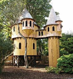 a wooden structure in the middle of a forest with two towers on each side and one at the top