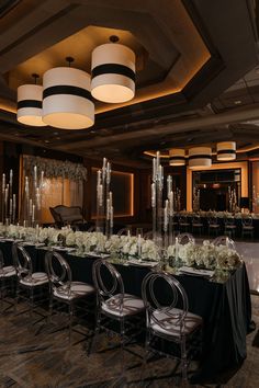 a long table is set up with chairs and centerpieces for a formal function