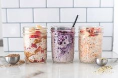 three jars filled with food sitting on top of a counter next to measuring spoons