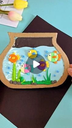 someone is making a fish pond out of cardboard and glue on the top of it