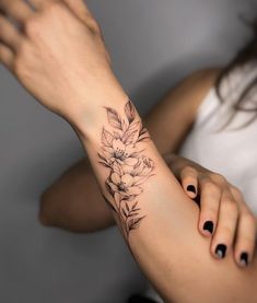 a woman's arm with a flower tattoo on it