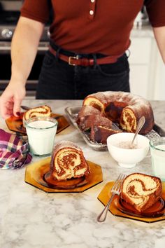 a man standing in front of a table filled with desserts