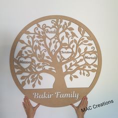 two hands holding up a family tree cutout