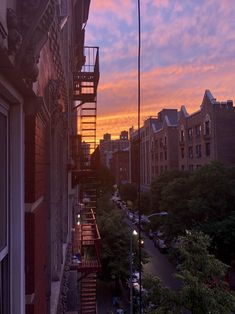 the sun is setting over a city street