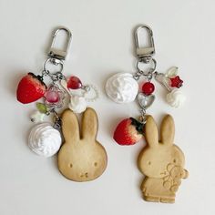 two bunny key chains with strawberries and whipped cream on them, one in the shape of a rabbit