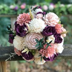 a bridal bouquet on a wooden bench in the park, with purple and pink flowers