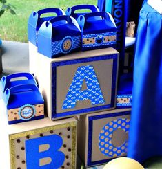 blue and brown boxes with letters on them are sitting in front of a tablecloth