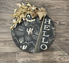 a black and white sign that says hello on the side of a wooden wall with flowers