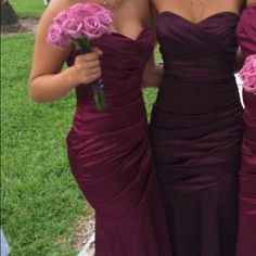 two bridesmaids in purple dresses holding pink roses