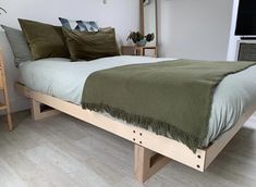 a bed with green blankets and pillows in a room