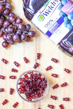 grapes and raisins on a cutting board next to a bottle of wine