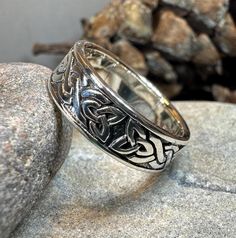 a silver ring sitting on top of a rock