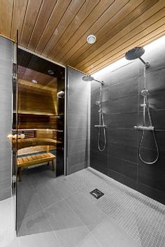 a bathroom with a wooden ceiling and glass doors that lead to the sauna room