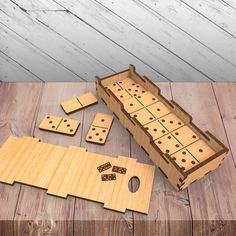 a wooden board game with dominoes and pieces laid out on the floor next to it