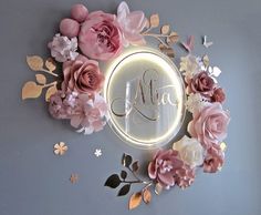 a lighted mirror with flowers and leaves around it that says mia on the front, surrounded by butterflies