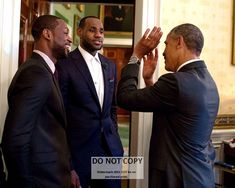 three men in suits are standing together and clapping