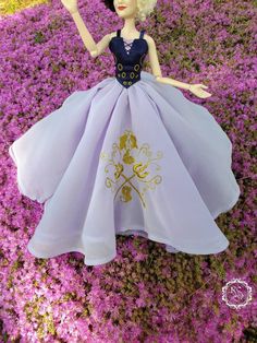 a barbie doll is laying in the middle of purple flowers