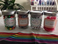 four jars filled with candy sitting on top of a table