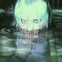 a girl with white hair is in the water and has her eyes closed while staring at something