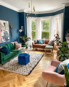 a living room filled with furniture and lots of plants on top of a hard wood floor