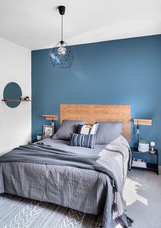 a bedroom with blue walls and grey bedding