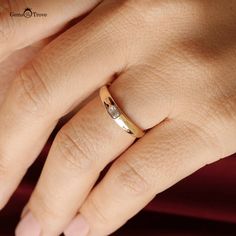 a woman's hand with a wedding ring on her left hand, wearing a gold band