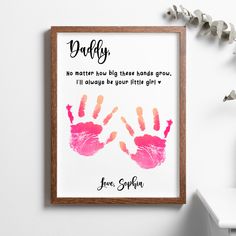 a framed print with two pink handprints on it