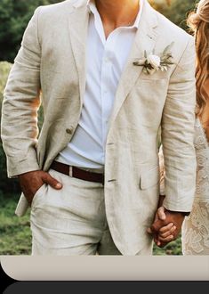 a man in a suit and tie holding the hand of a woman wearing a wedding dress