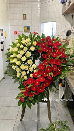 a bunch of flowers that are sitting on a stand in a room with tile flooring