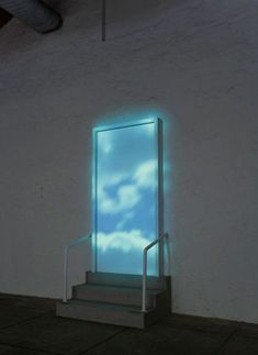 an open door with blue sky and clouds projected on the wall in front of it