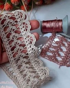 someone is working with some thread to make a piece of lace that looks like something out of an old book