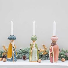 three candles sitting on top of a mantle