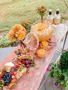 a table topped with oranges, grapes and other fruits