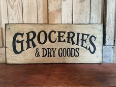 a wooden sign that says groceries and dry goods