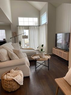 a living room filled with furniture and a flat screen tv on top of a wooden table