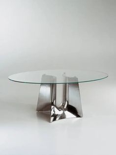 an oval glass table with metal legs on a white background in the style of sci - fi