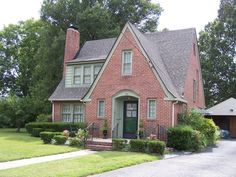 a red brick house sitting on the side of a road