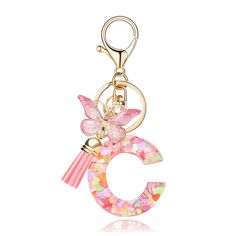 a pink and gold key chain with a butterfly on the letter c in floral print