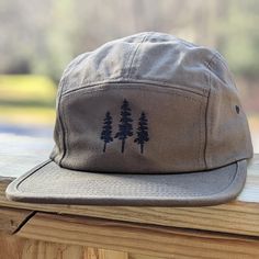 🌲🌲 5% of profits donated to preservation 🌲🌲  Gear up for your next adventure with our olive green tree 5 panel hat, the ultimate camp hat! Crafted from 100% cotton, this hat's flat bill keeps you cool and shaded as you conquer trails, lounge by the campfire, or explore the great outdoors. Your new adventure-ready essential! This hat is olive green with black embroidered trees on the front. Embroidery is custom designed by the shop owner, Alyssa, stitched on front. - 100% cotton - 5 Panel, Ca Military Hat With Flat Bill For Outdoor Activities, Military Flat Bill Hat For Outdoor Activities, Adjustable Khaki Hat For Hiking, Military Snapback Hat With Flat Bill For Outdoor, Adjustable Khaki Hiking Hats, Military Style Flat Brim Trucker Hat For Outdoor, Khaki Curved Brim Bucket Hat For Camping, Khaki Snapback Trucker Hat For Outdoor Activities, Military Style Baseball Cap With Short Brim