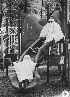 a black and white photo of a child's play area with slides, climbing equipment and towels