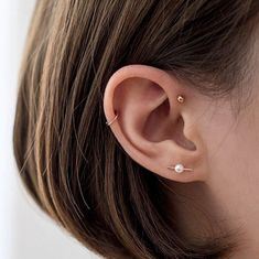 a close up of a person wearing a pair of ear piercings